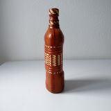 Vintage glass bottle covered with light brown leather and wicker