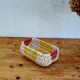 Vintage woven basket in yellow, white, and pink plastic.