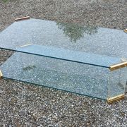 1970s designer coffee table in glass, plexiglass, and gold metal.