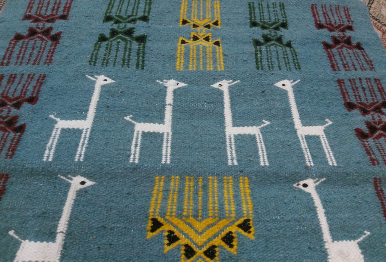 Blue carpet with gazelle patterns woven by hand