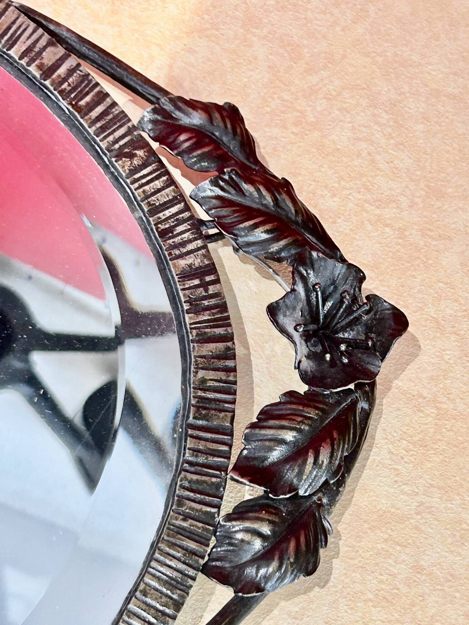 Bevelled oval mirror, richly crafted Art Deco wrought iron.