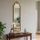 Narrow and tall antique mirror, adorned with golden patterns.