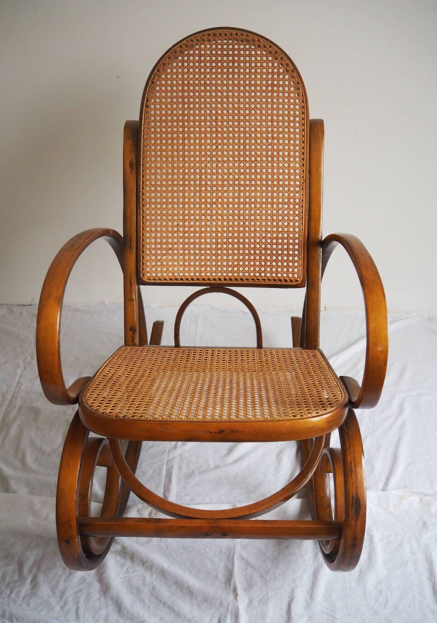 Rocking-chair en bois teinté et assise cannée