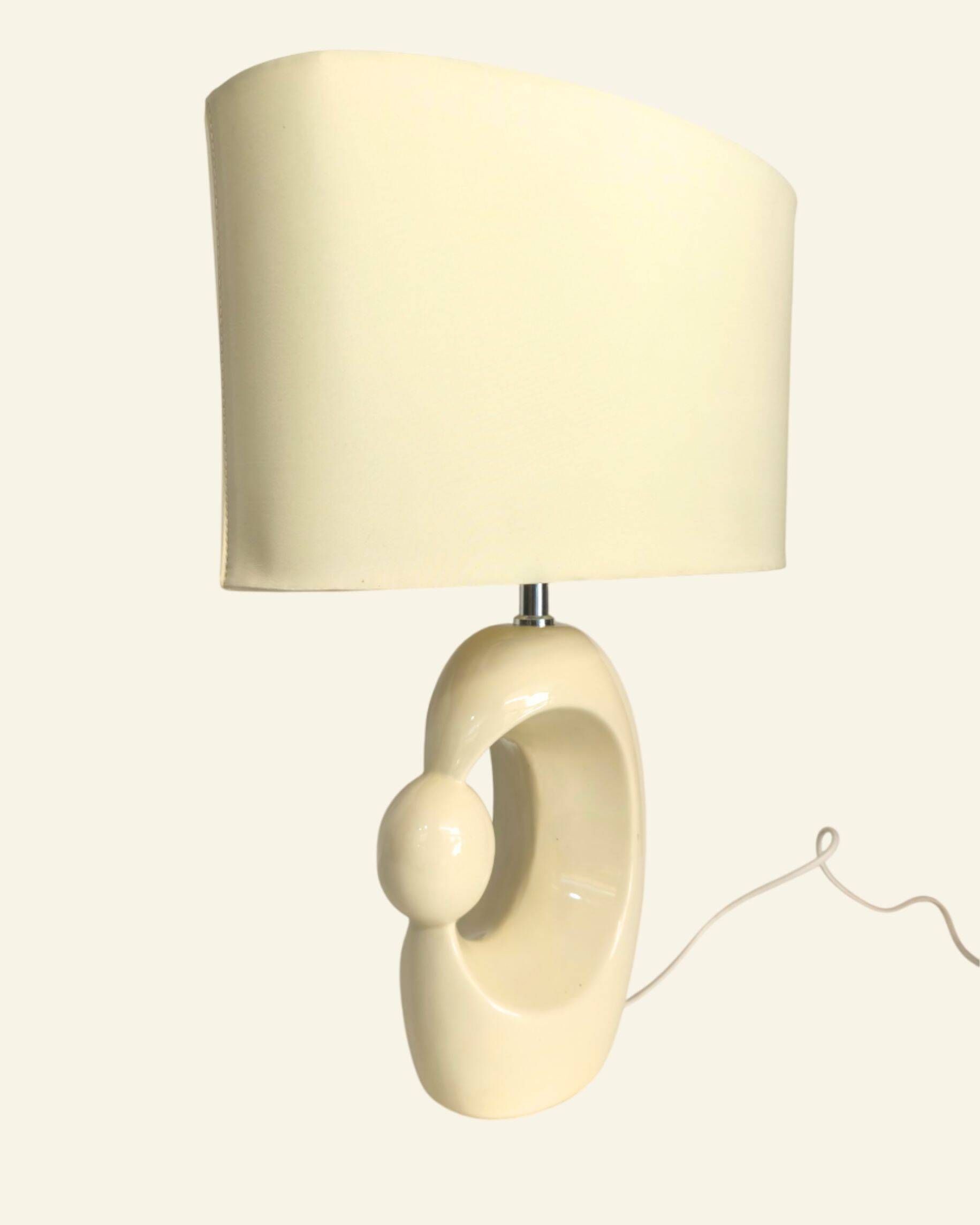 Cream ceramic table lamp with a mid-century design, featuring a lampshade.