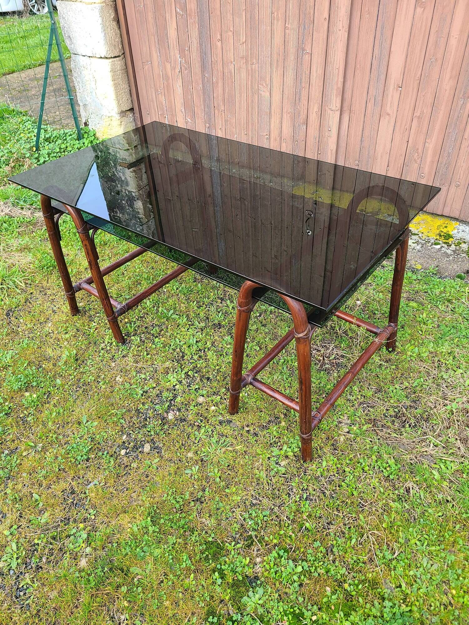 Smoked glass desk on rattan legs and leather detail