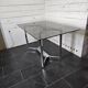 Table en métal chromé dessus verre fumé