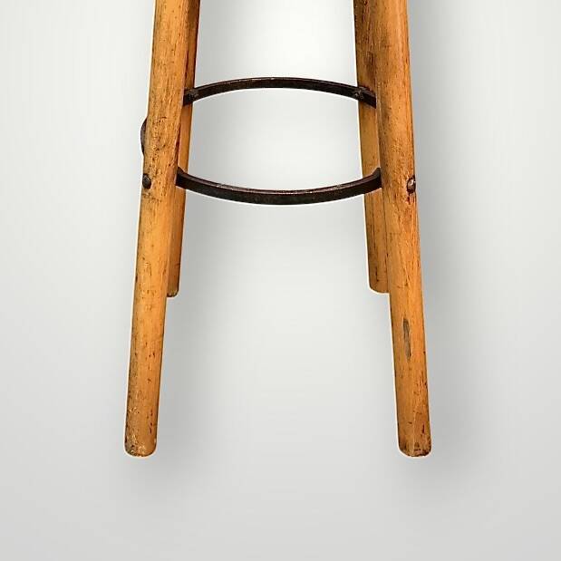 Old solid wood bar stool, metal footrest, green leatherette seat