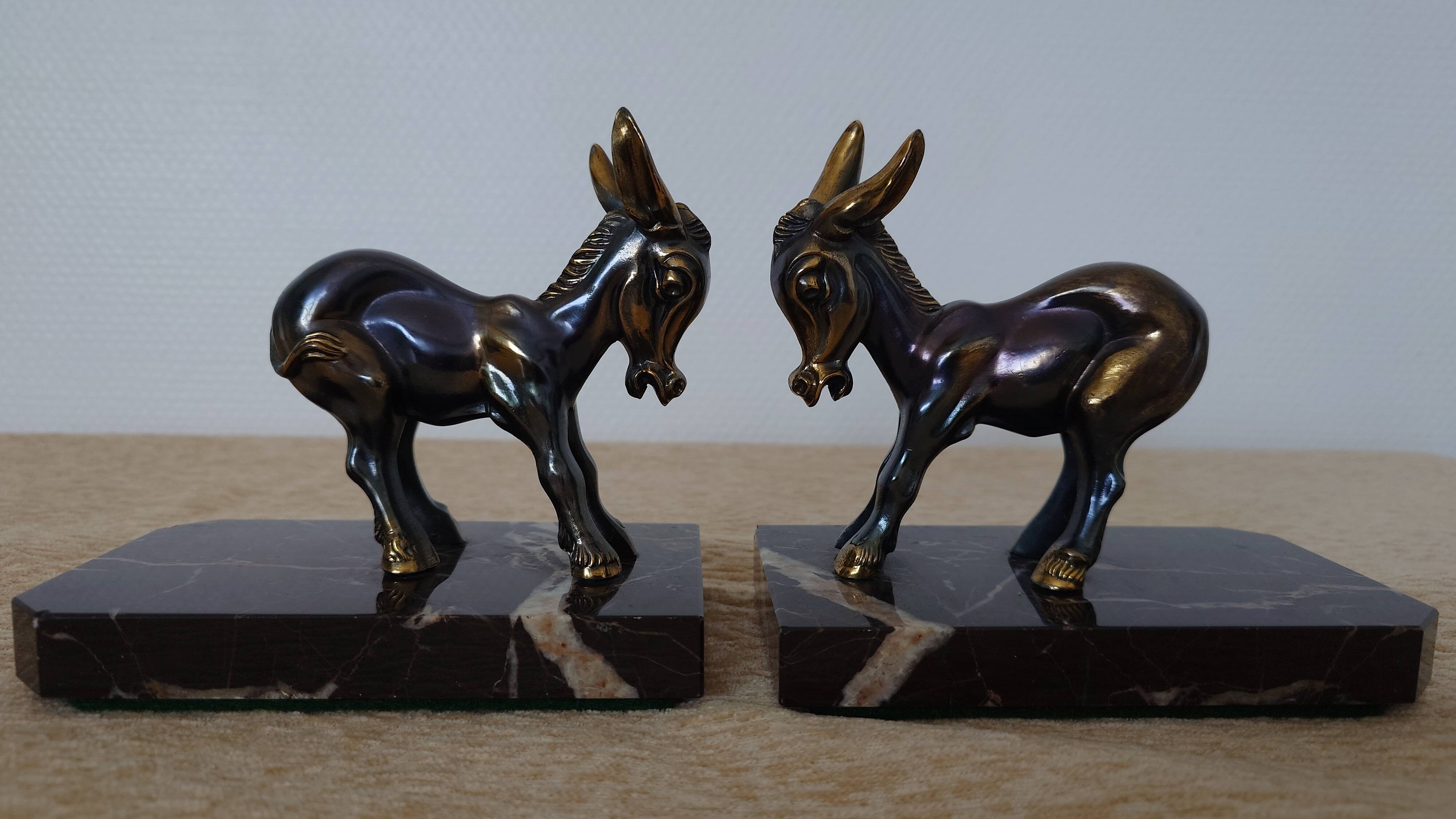 Bookends in the style of stylised donkeys, patinated metal and marble - circa 1940-1950.