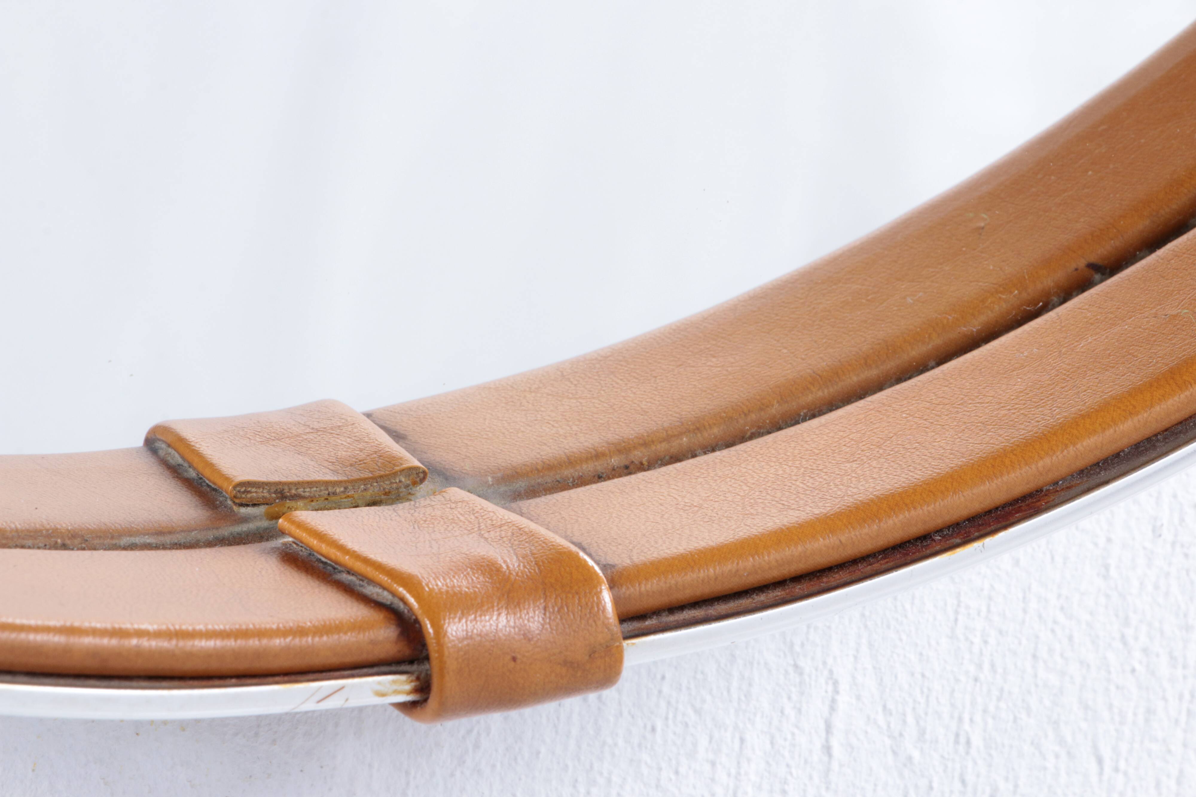 Round mirror covered with leather and chrome, made in France in the 1970s.