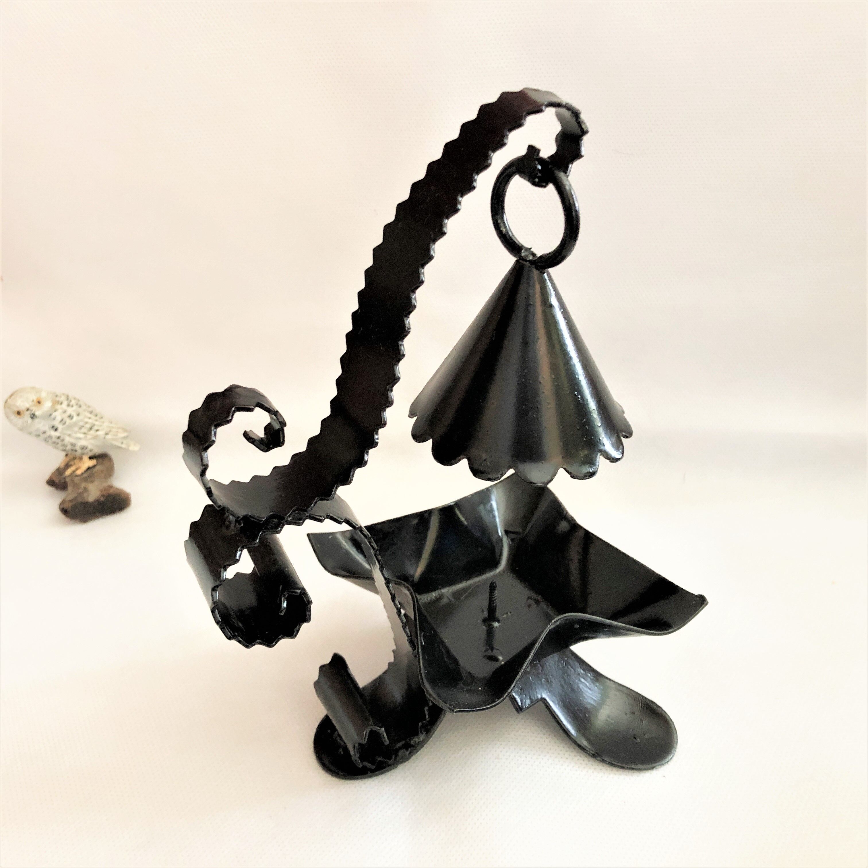 Handcrafted black wrought iron candle holder with its vintage extinguisher
