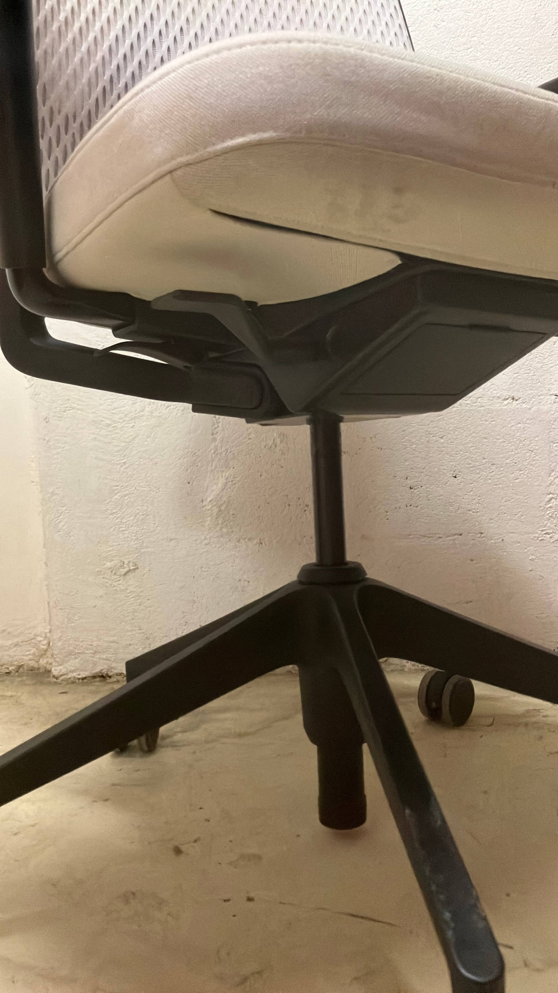 Office chair with wheels and mesh backrest.