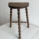 Three-legged demi-lune stool made of turned wood