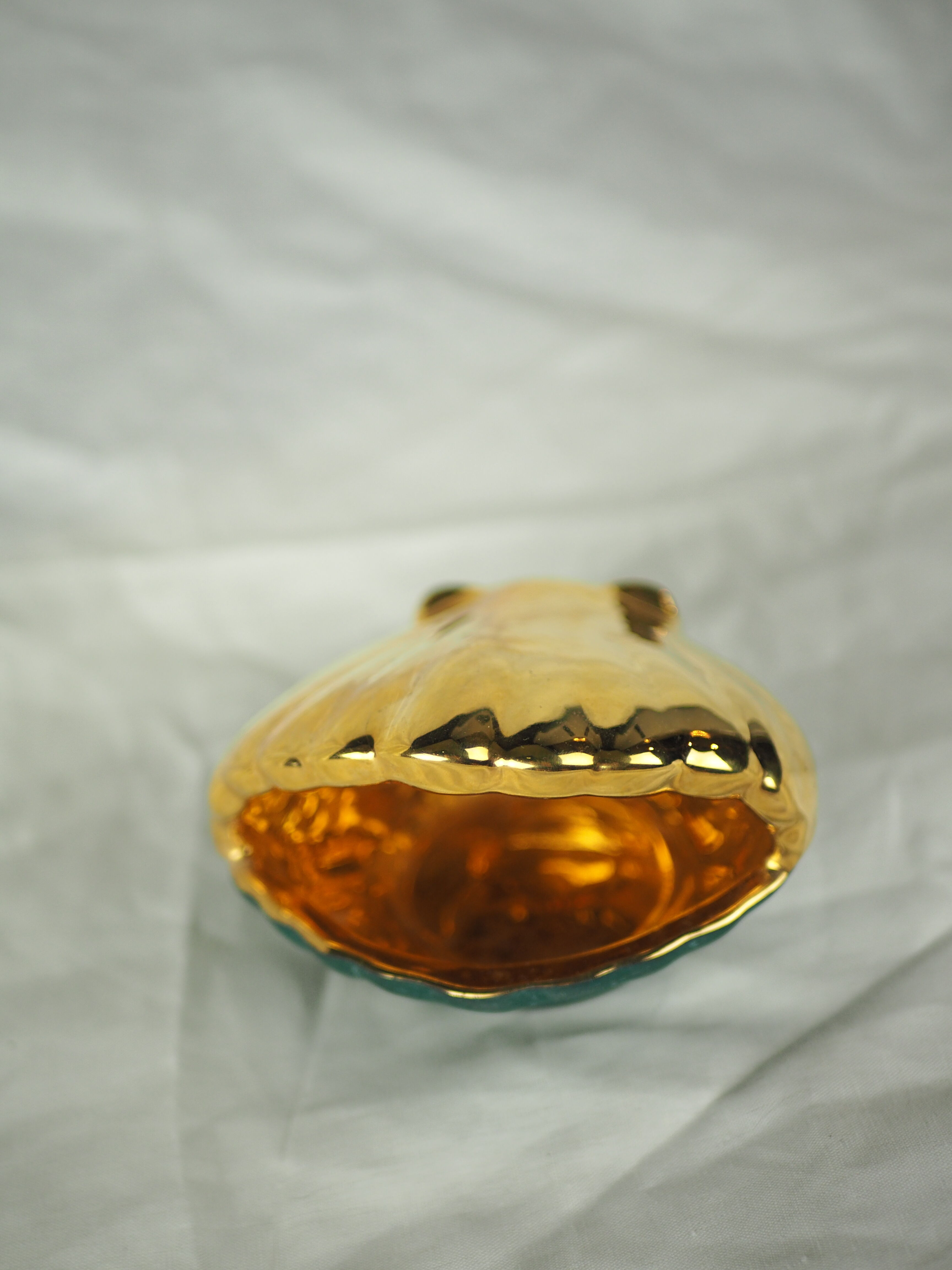 Porcelain pocket tray in the shape of a golden scallop shell with duck green background from the 50s/60s