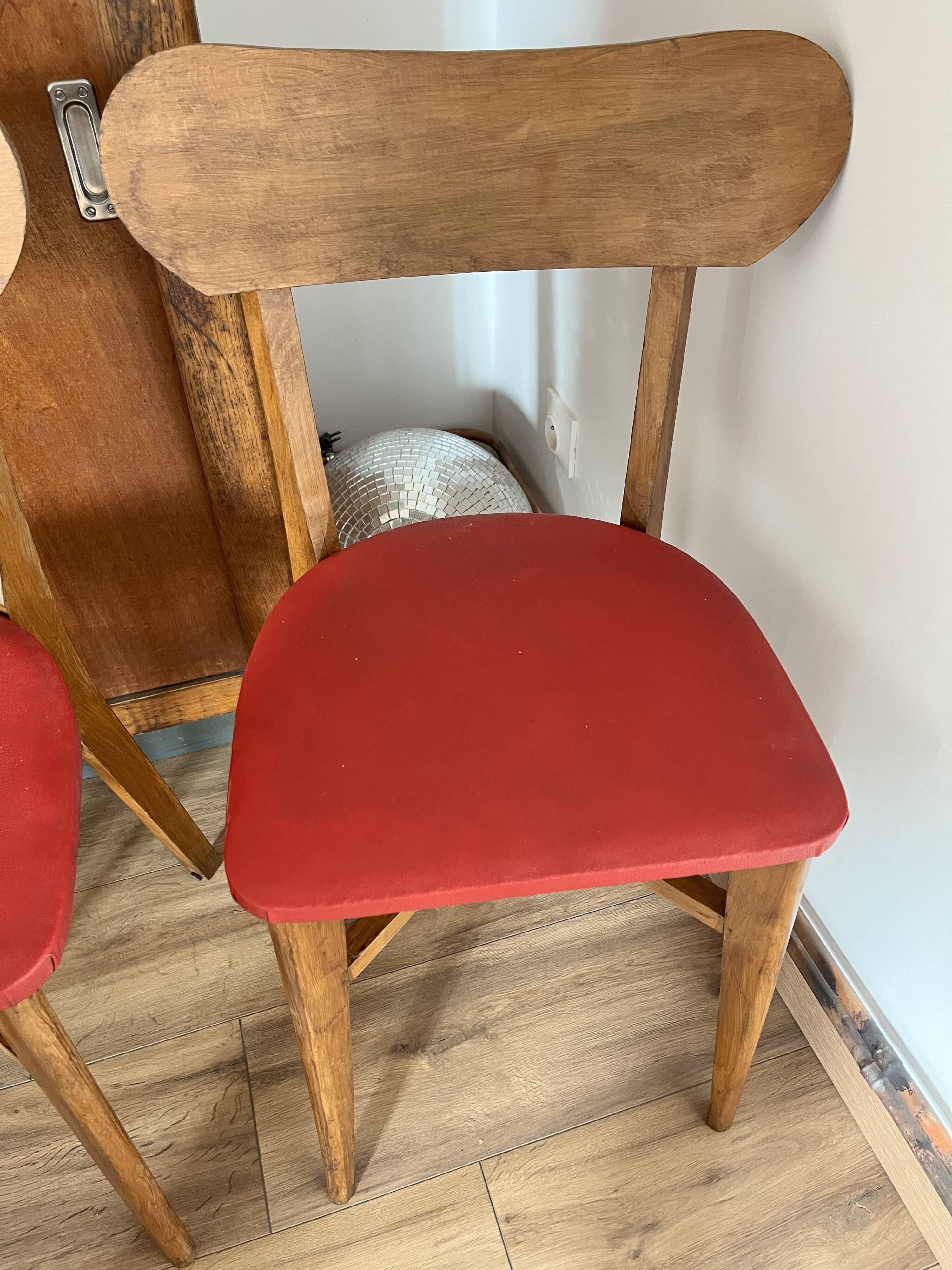 Set of 4 wooden chairs with red vinyl.
