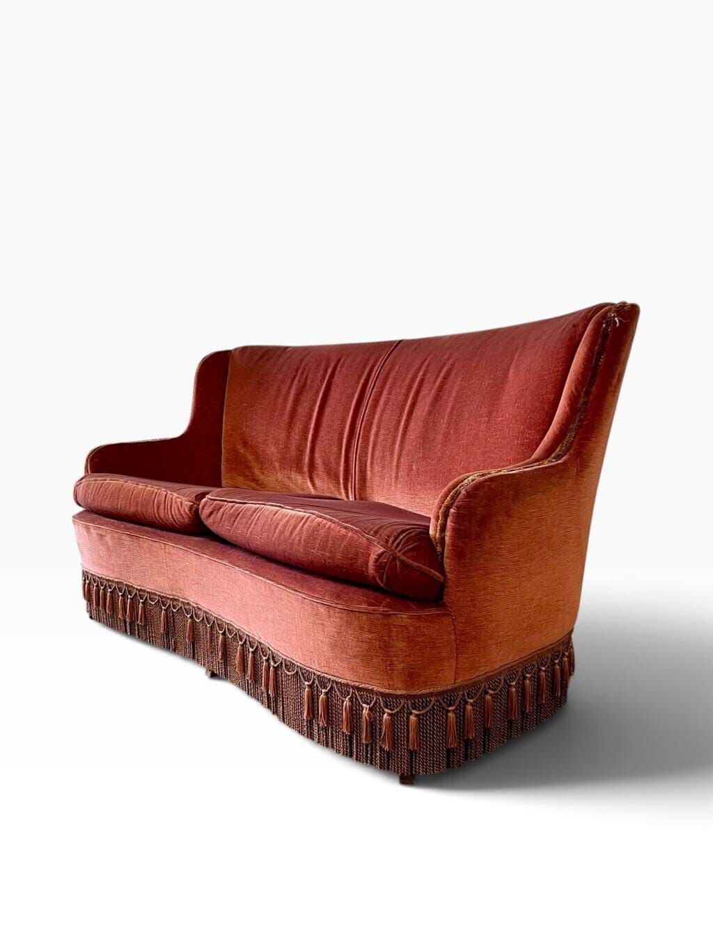 Vintage two-seater armchair in powder pink velvet with fringes.