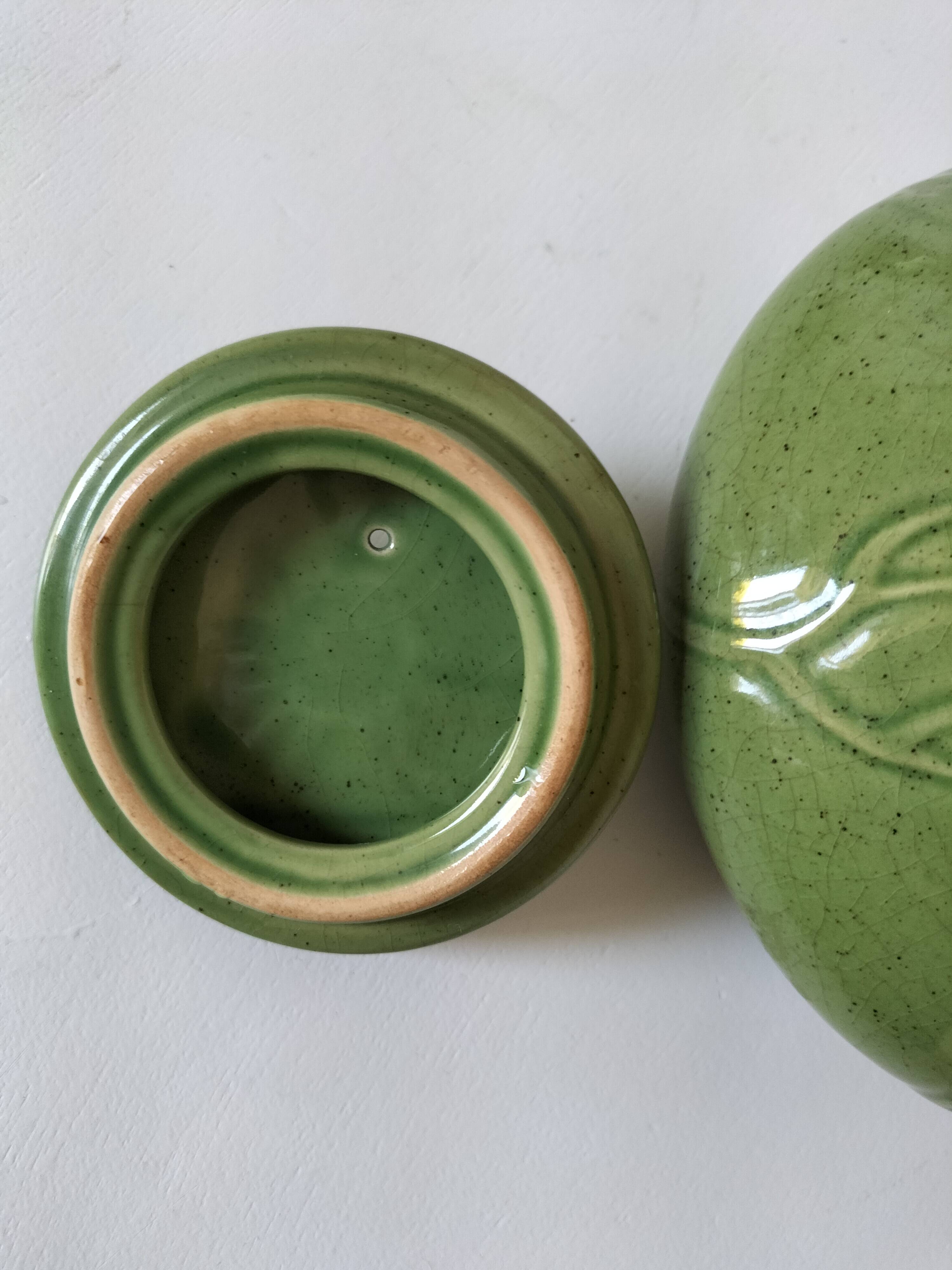 Vintage green teapot with lotus decoration and bamboo handle.