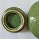 Vintage green teapot with lotus decoration and bamboo handle.