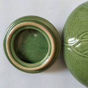 Vintage green teapot with lotus decoration and bamboo handle.