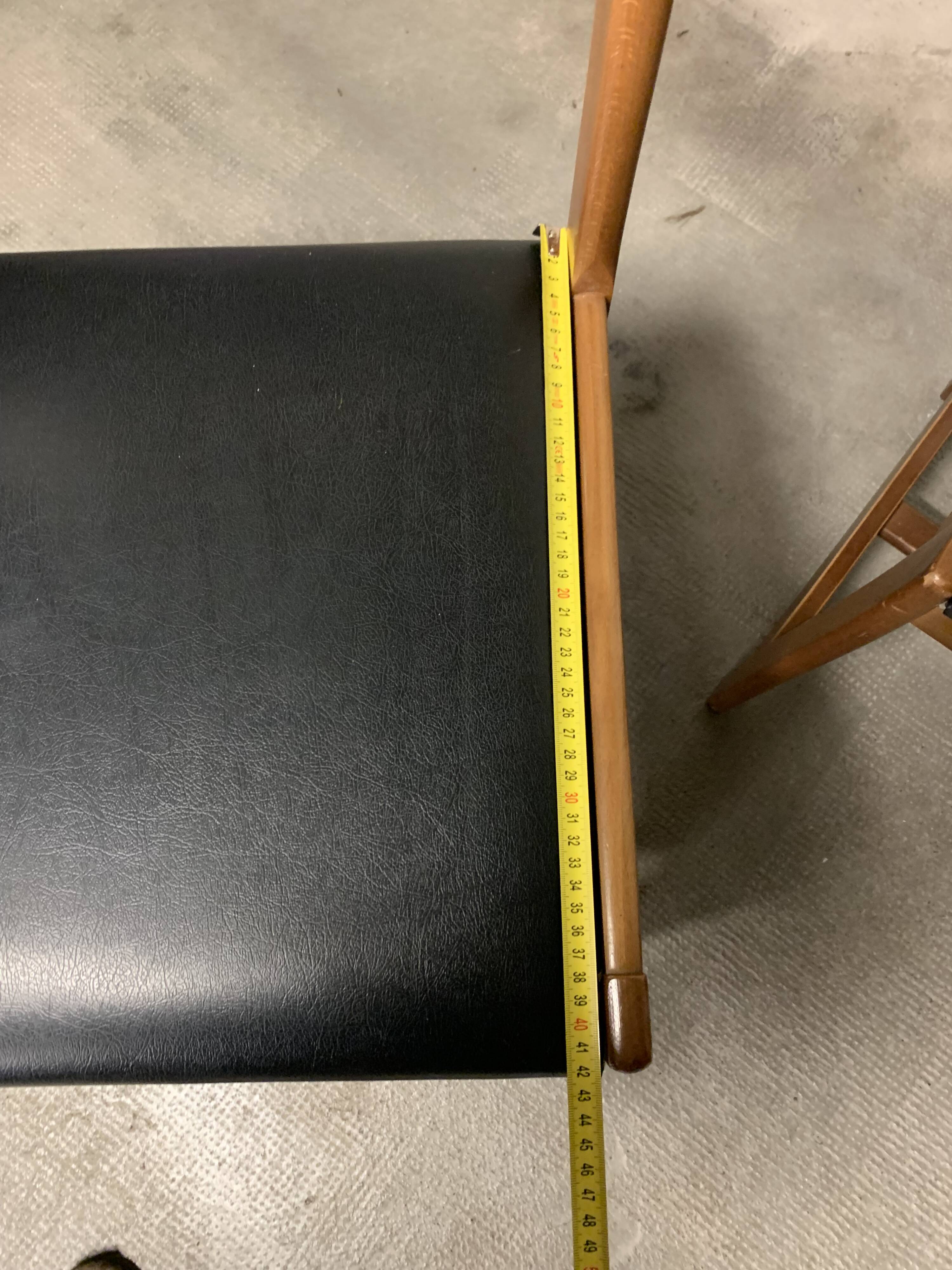 Set of four vintage chairs upholstered in retro design faux leather.