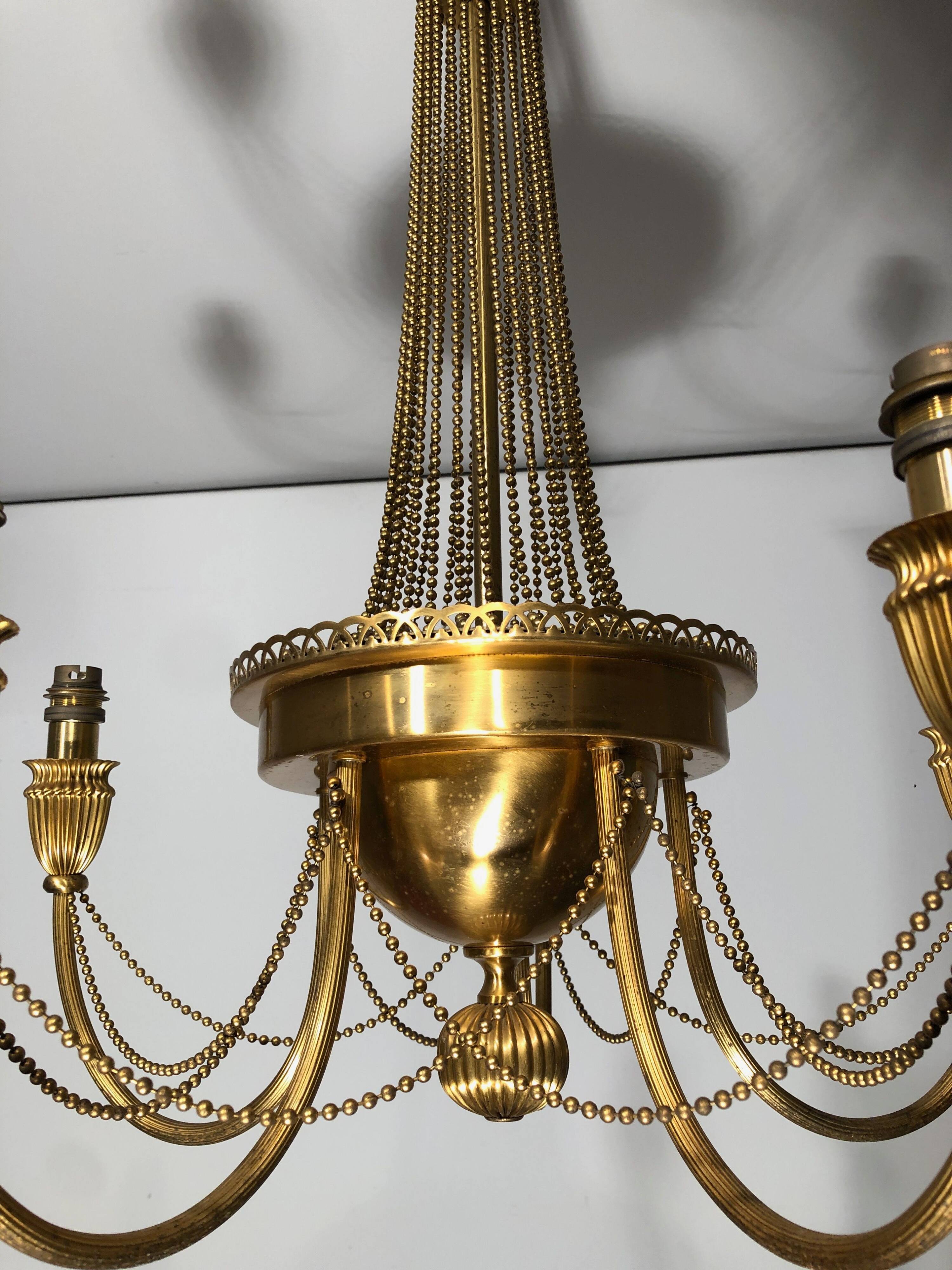 Neoclassical style brass chandelier decorated with pearl garlands