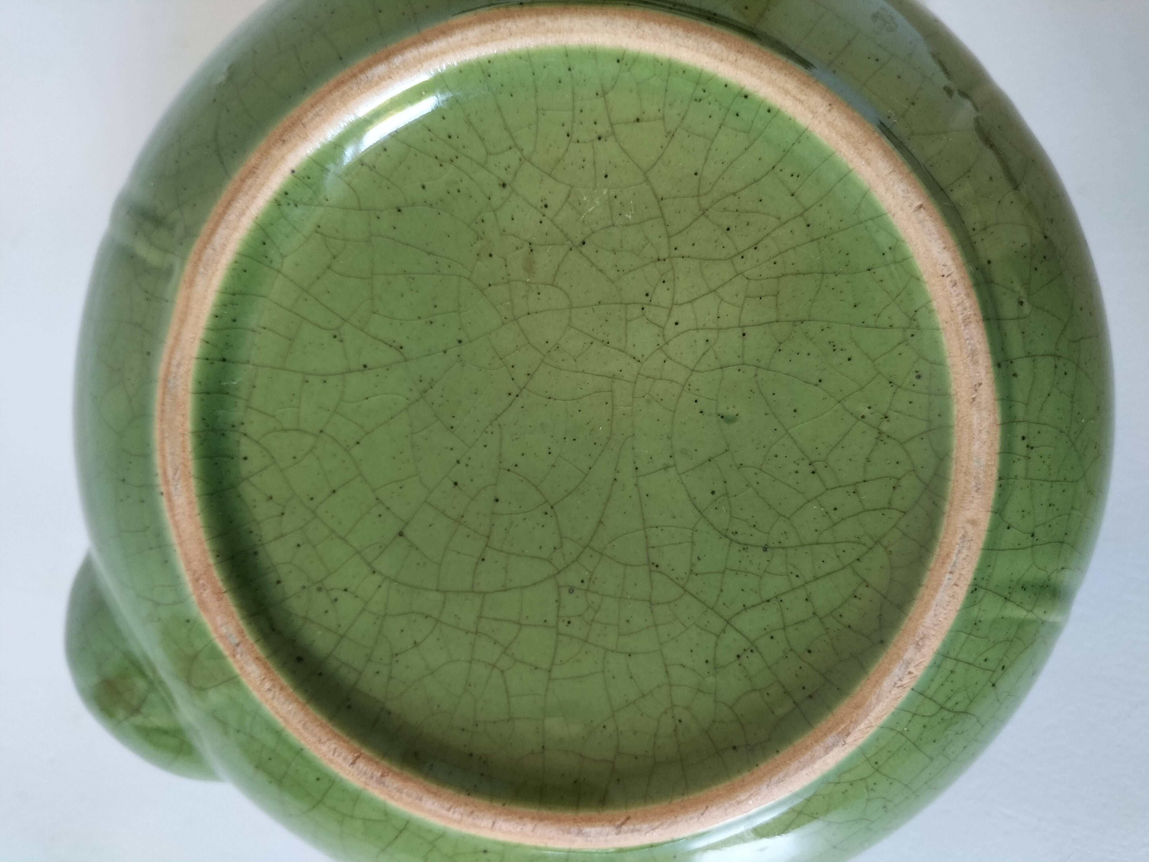 Vintage green teapot with lotus decoration and bamboo handle.