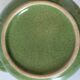 Vintage green teapot with lotus decoration and bamboo handle.