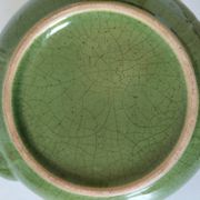 Vintage green teapot with lotus decoration and bamboo handle.