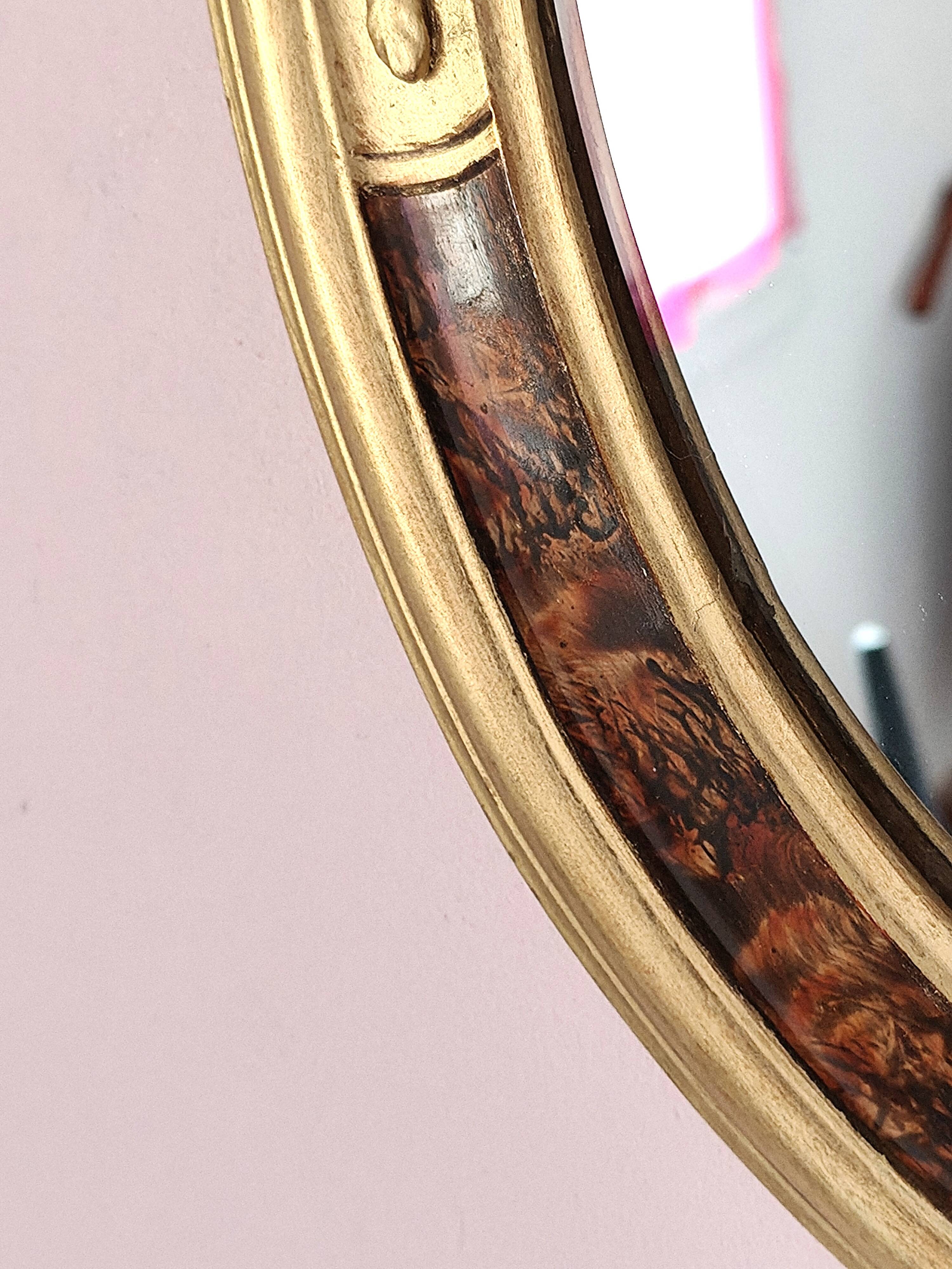 Antique medallion mirror with a gilded and relief-carved frame.