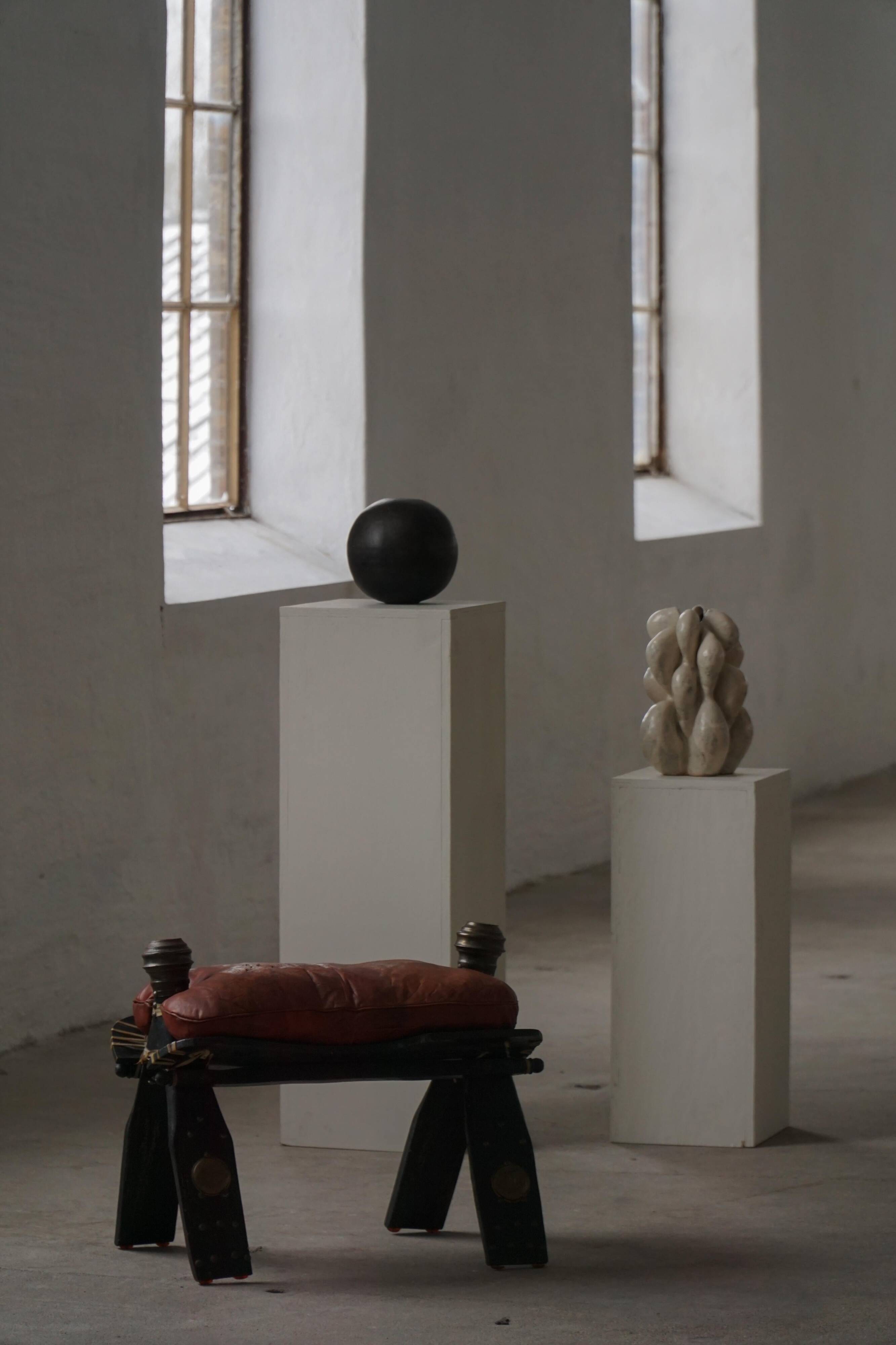 Dark red upholstered camel saddle stool, 20th century, North Africa.