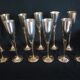 Lot of 12 silver metal flutes on brass stand