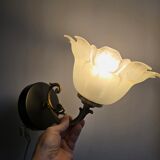 Frosted glass tulip wall sconces with brass arms.