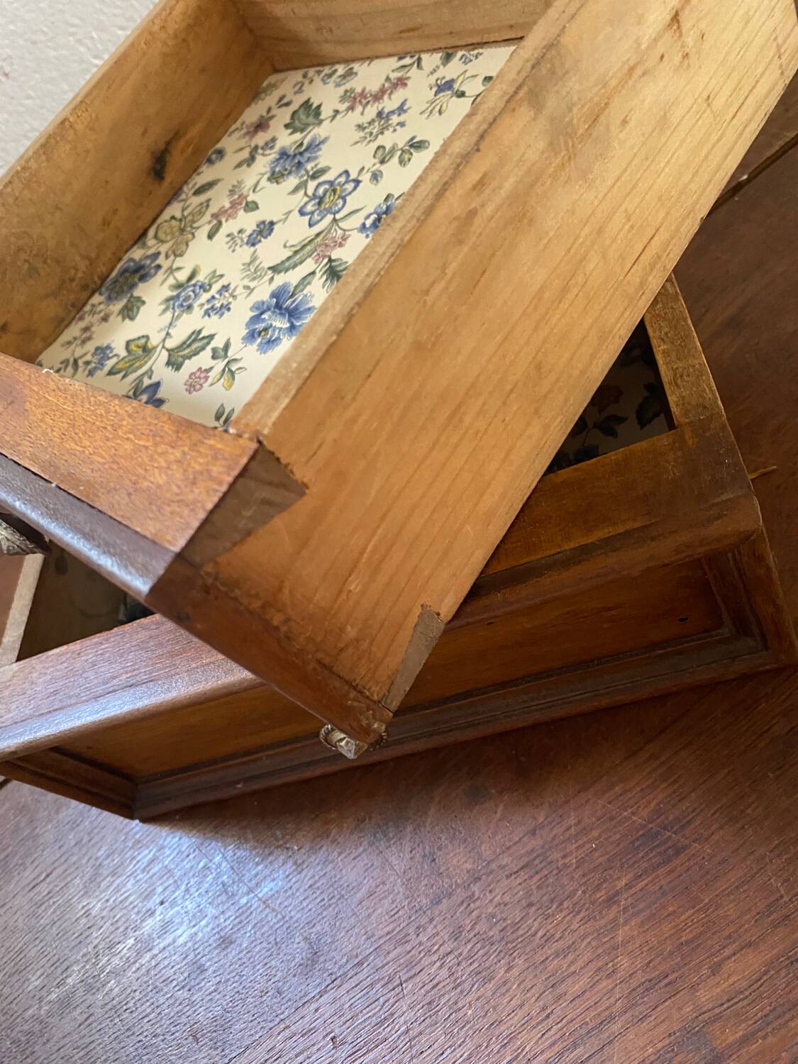 2 tiroirs en bois au bouton en laiton ciselé .