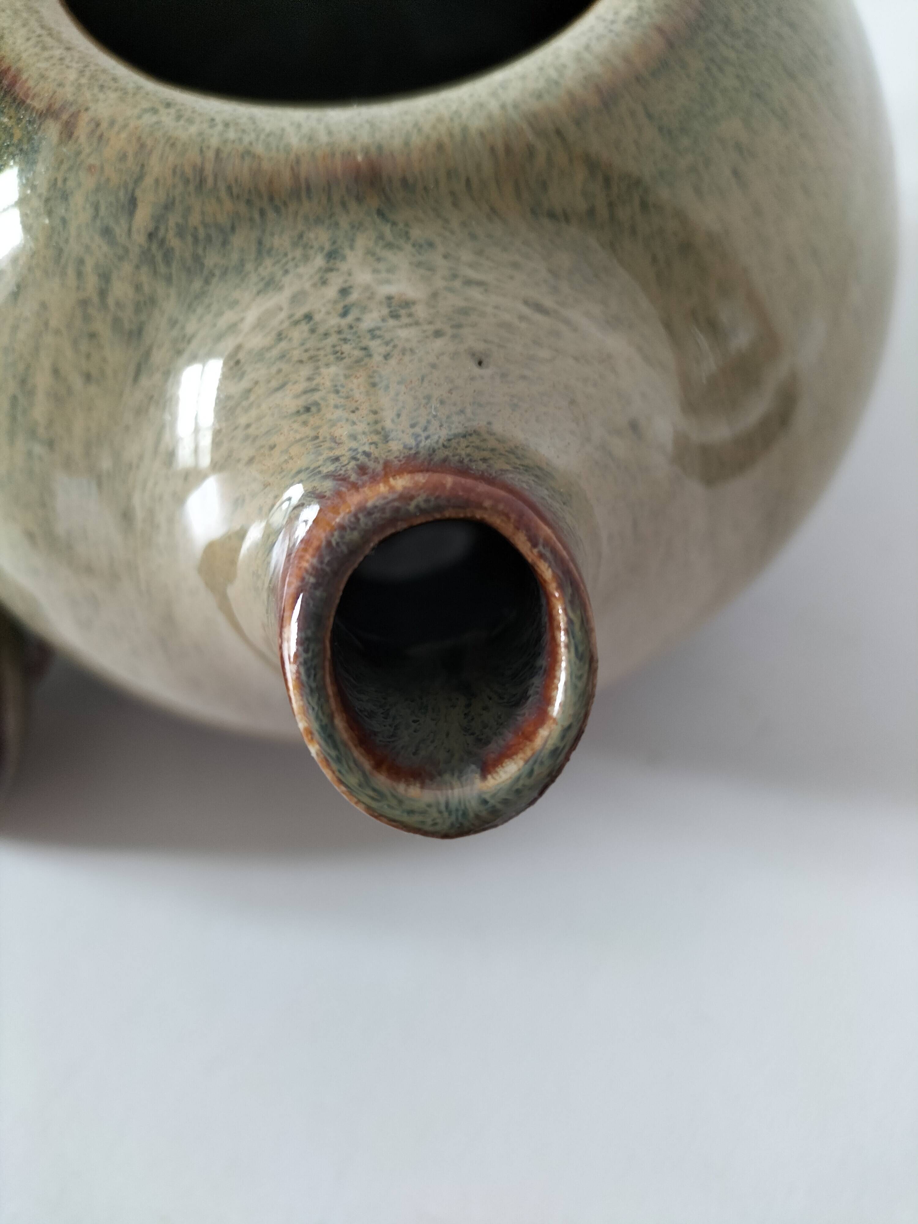 Vintage ceramic teapot with a flame design.