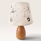 Wood-turned lamp with a hand-drawn lampshade, circus patterns.