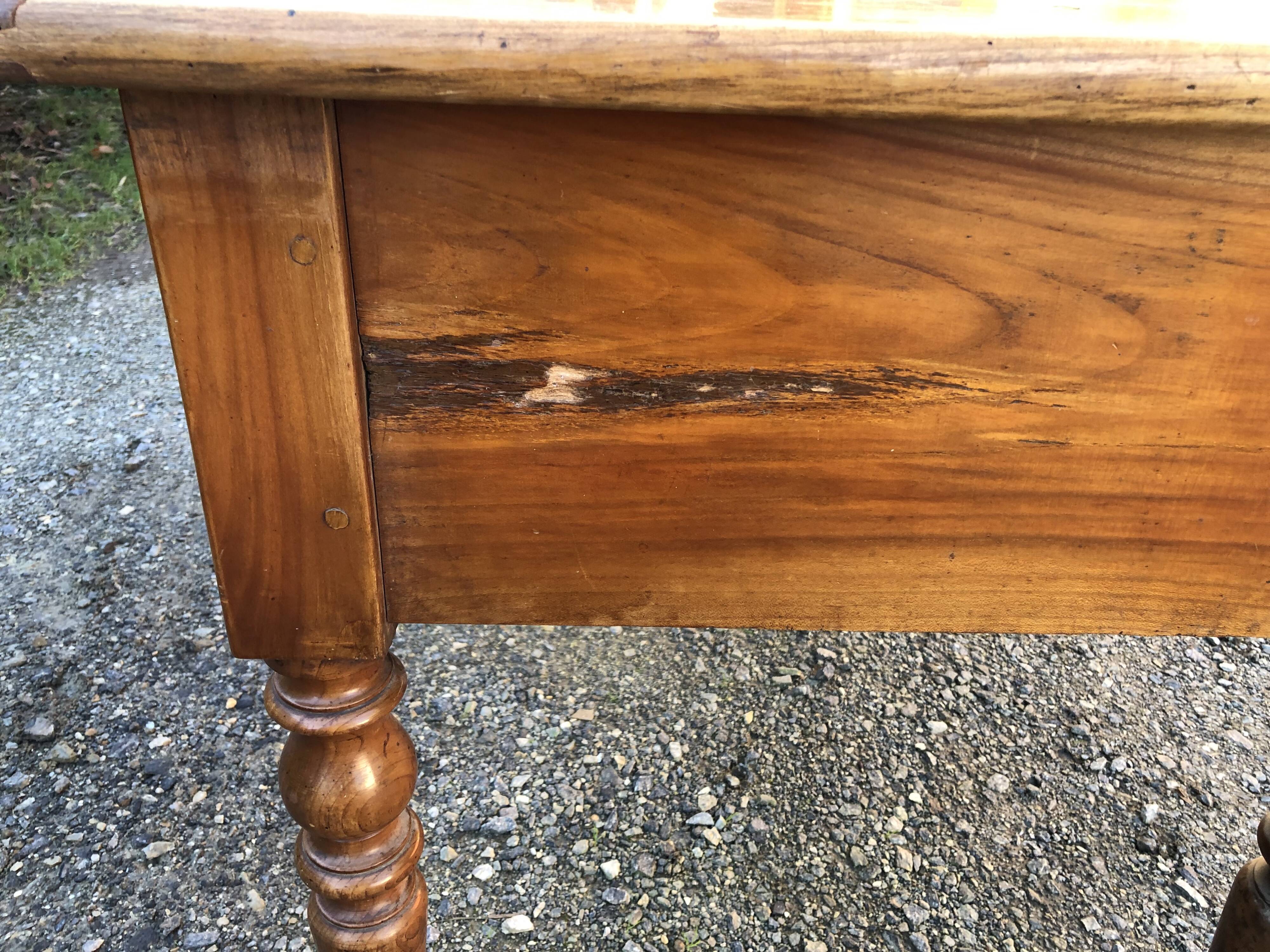 Antique cherry farmhouse table with turned legs and 2 drawers.