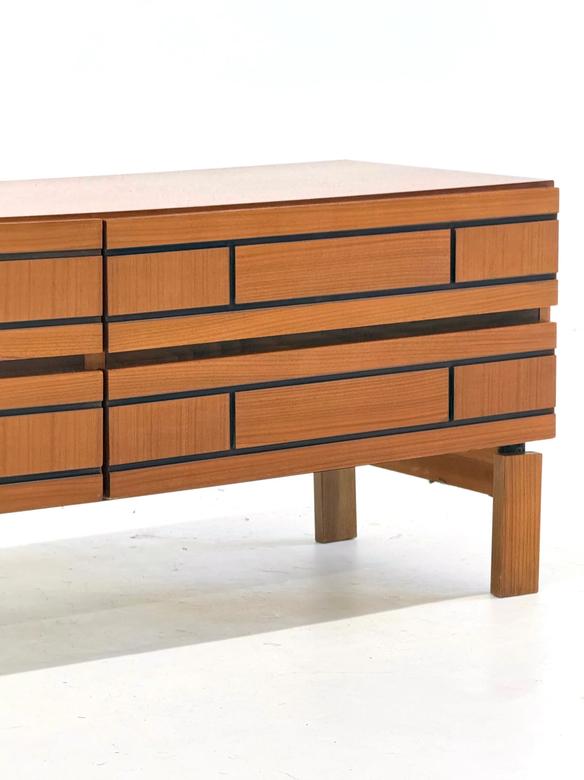 Buffet bas en bois italien avec des lignes noires graphiques.