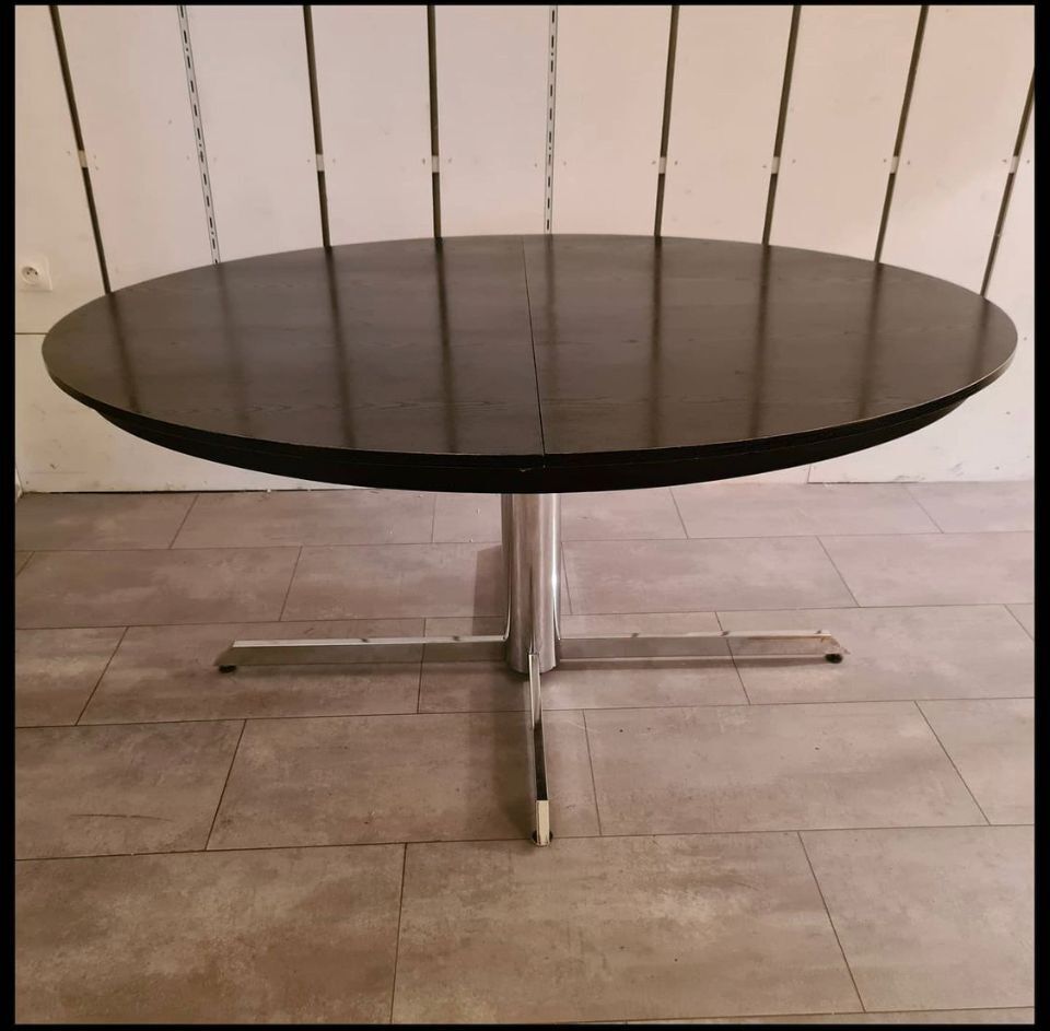 Blackened wooden dining table and chrome foot with integrated butterfly extension