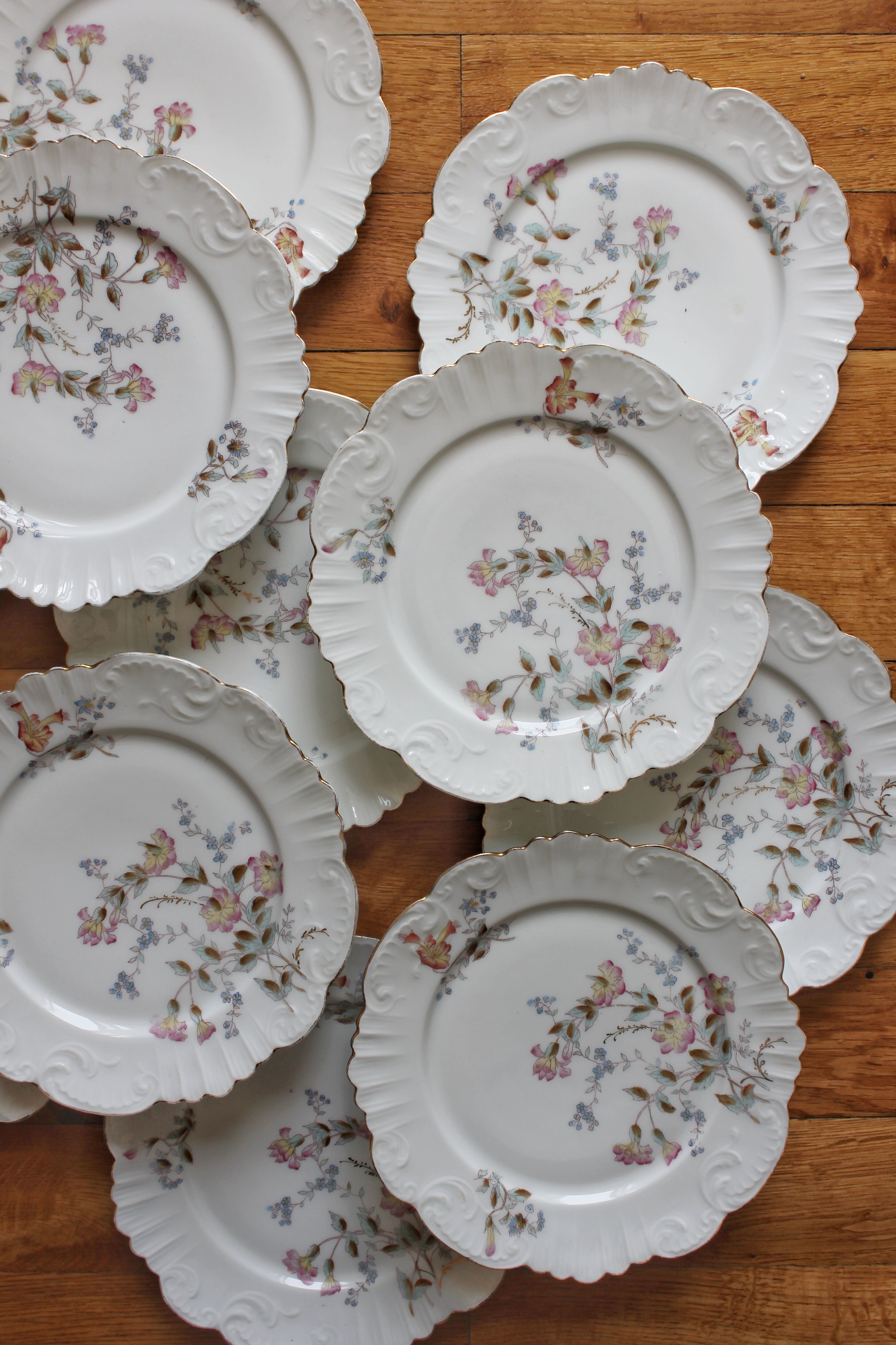 12 assiettes à dessert en porcelaine ancienne décor polychrome floral début XXe