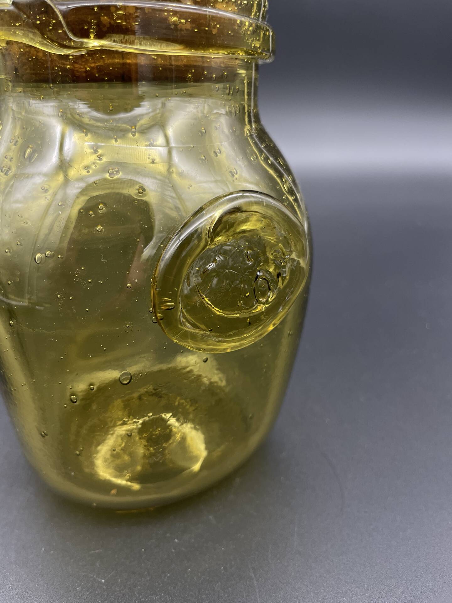 Yellow bubbled glass apothecary jar with cork lid.