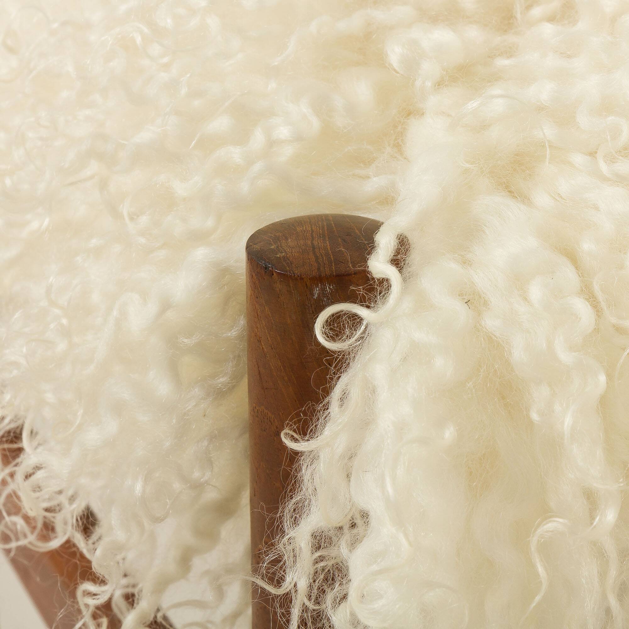Pouf en teck danois des années 60 recouvert de peau de mouton à poils longs.
