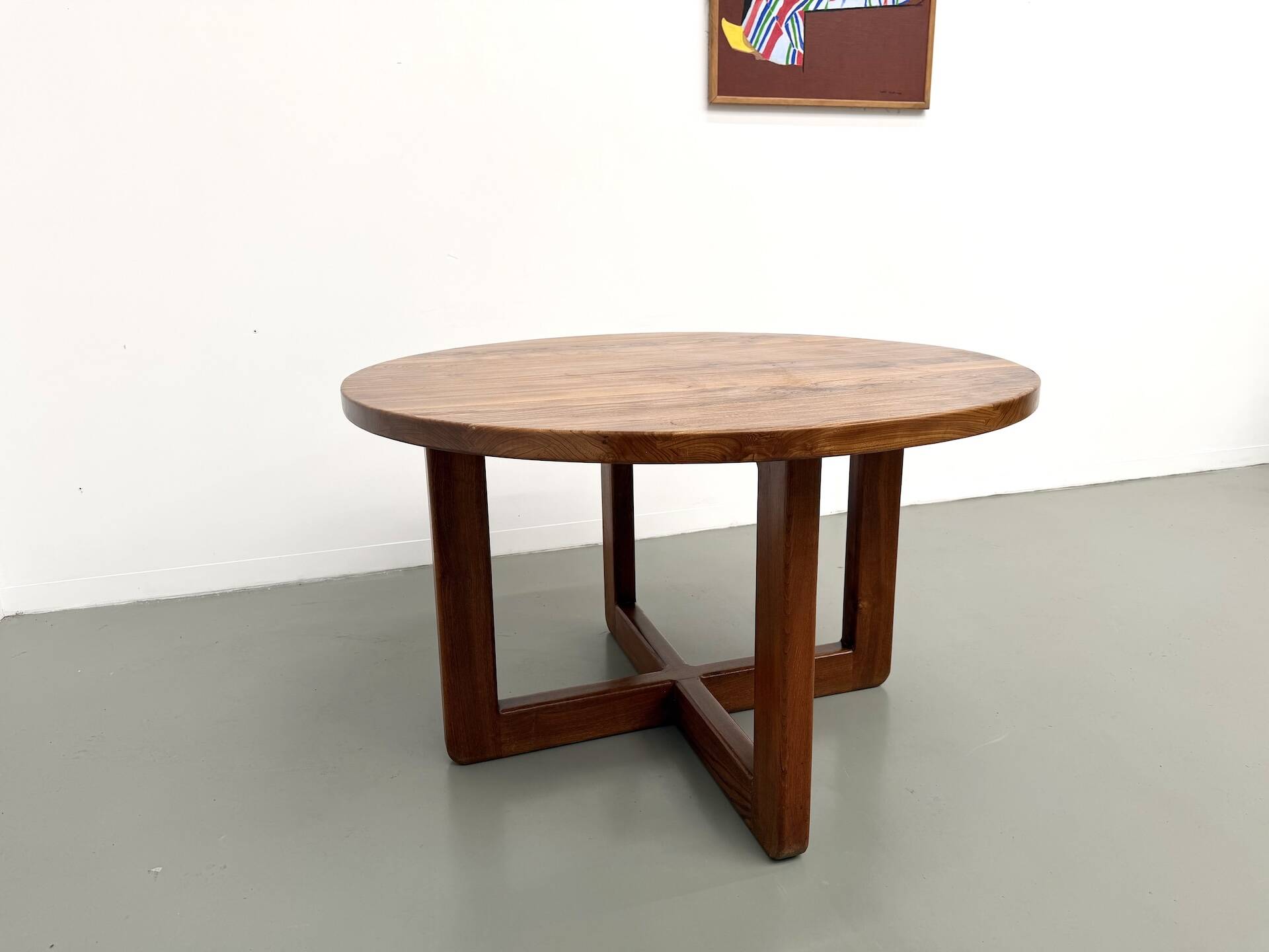 Modernist round table in solid elm, crossed legs.