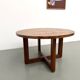 Modernist round table in solid elm, crossed legs.