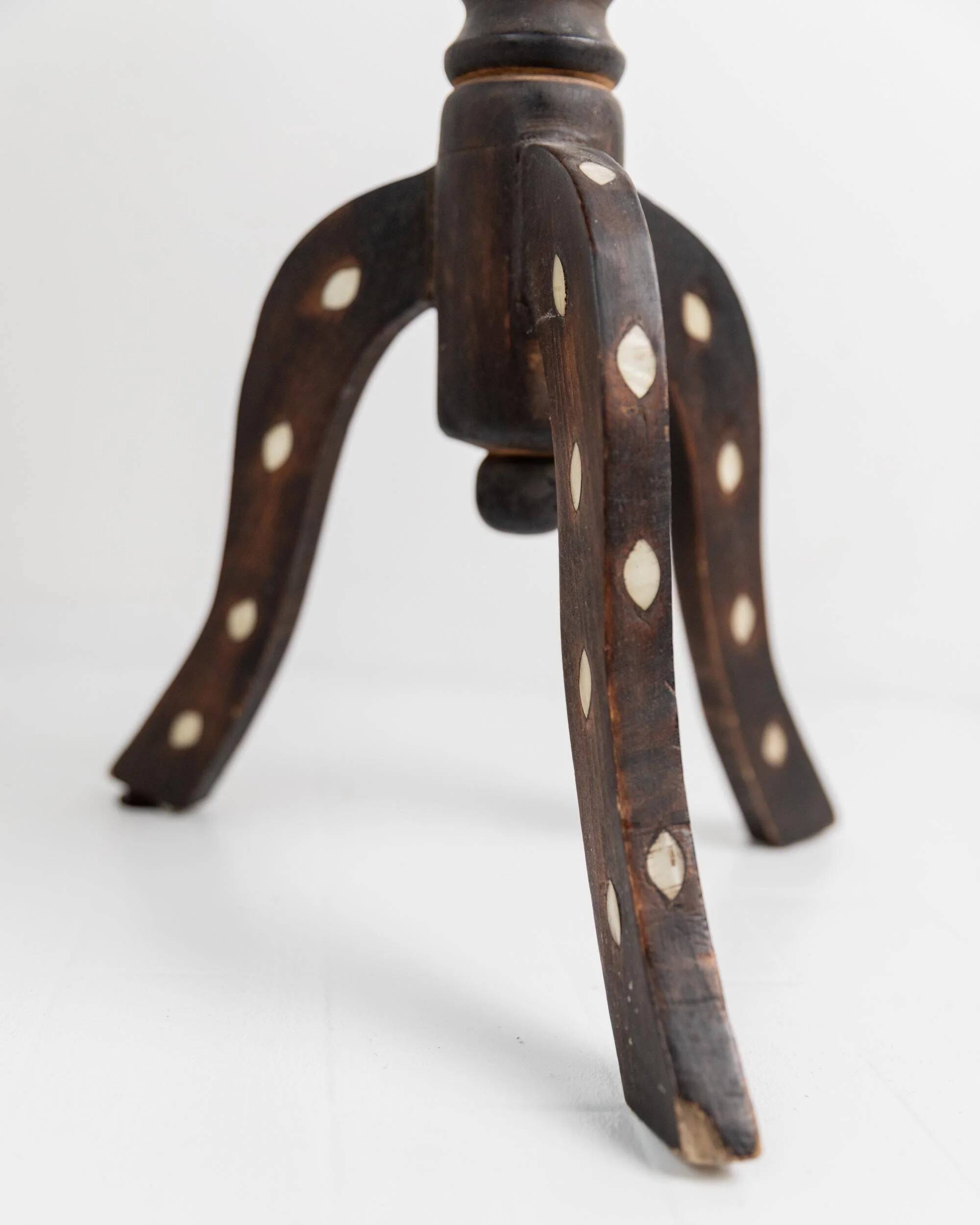 Vintage side table from the early 19th century, dark wood with mother-of-pearl inlays, oval shape with three legs, ethnic style.