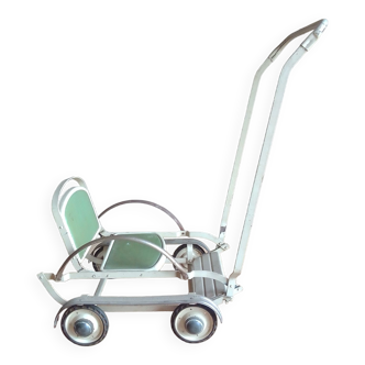 Old foldable stroller on metal wheels. Toy from the 50s