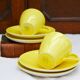 A pair of vintage bright yellow Poole Pottery - Two cups, saucers and ace