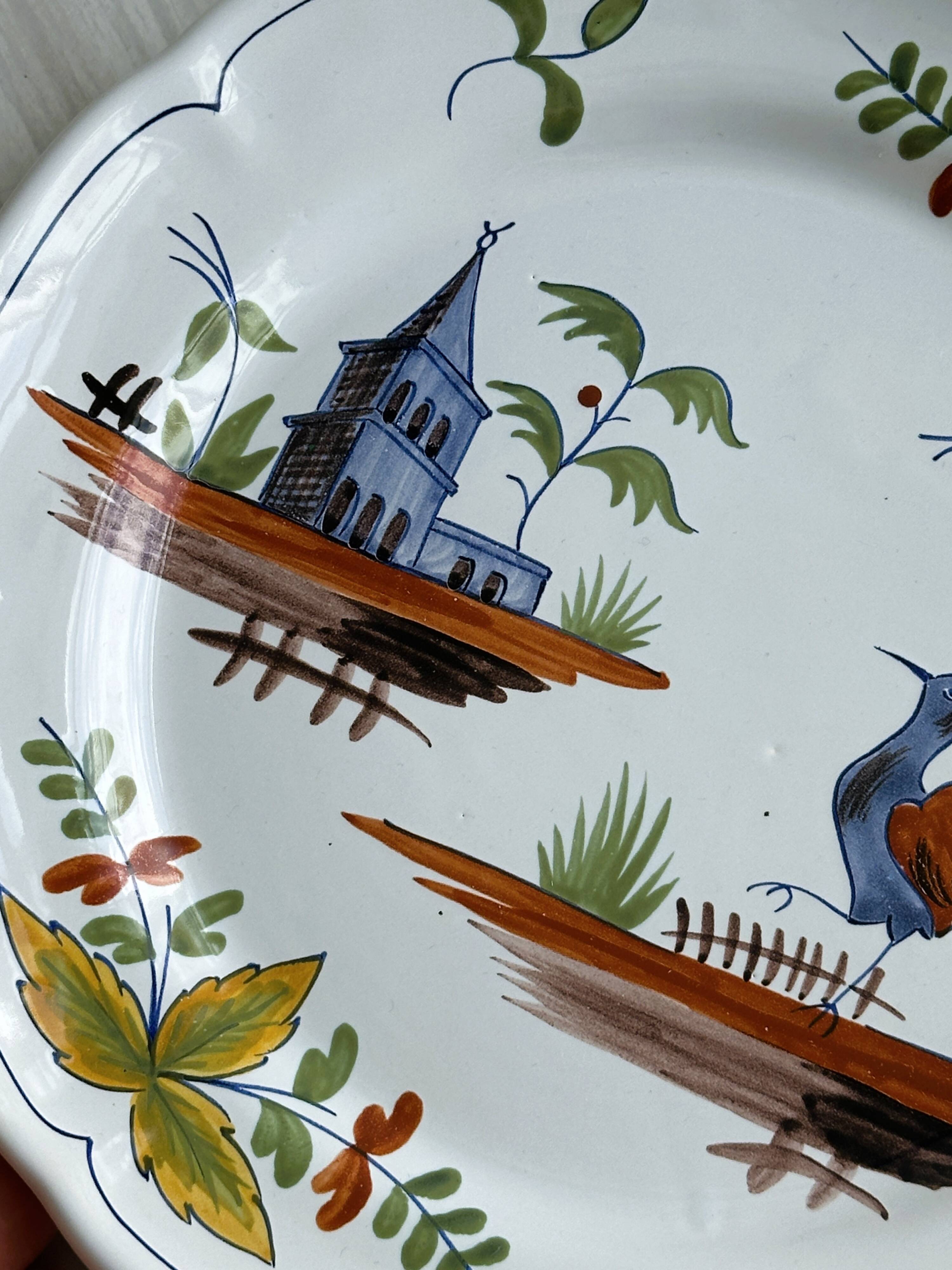 Hand-painted earthenware plate with landscape and bird decoration.