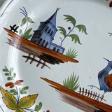 Hand-painted earthenware plate with landscape and bird decoration.