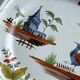 Hand-painted earthenware plate with landscape and bird decoration.