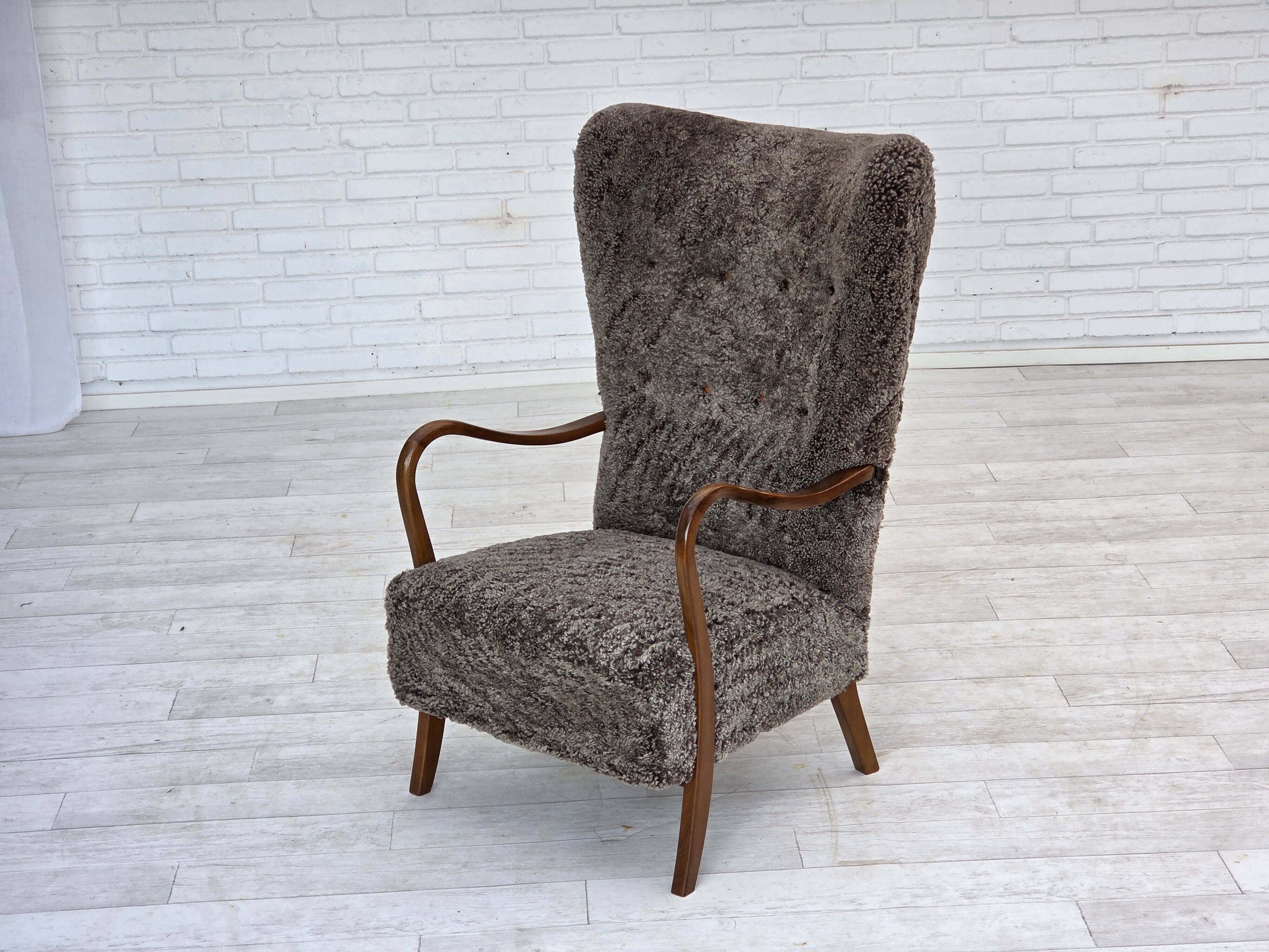 1960s, reupholstered Danish armchair, with stool, genuine sheepskin.