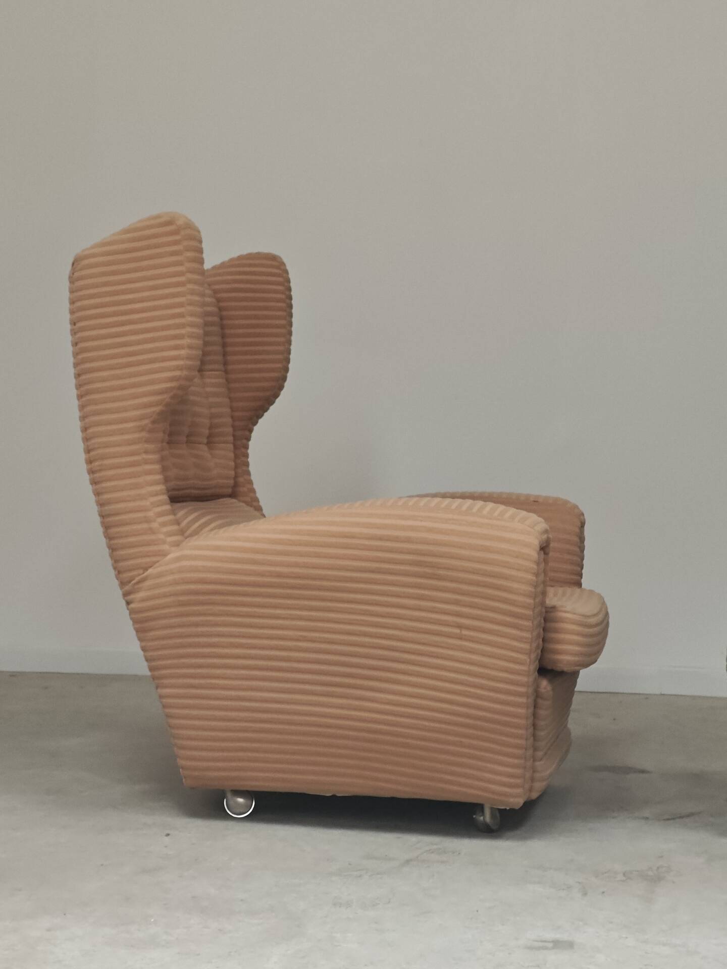 Beige wingback armchair and TVAR footrest, former Czechoslovakia.